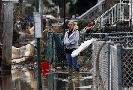 A woman stands alone in water in front of destroyed homes on Cedar Grove Avenue in a neighborhood where many houses were heavily damaged or completely destroyed by storm surge flooding from Hurricane Sandy on the south side of the Staten Island section of New York City, November 1, 2012. A woman stands alone in water in front of destroyed homes on Cedar Grove Avenue in a neighborhood where many houses were heavily damaged or completely destroyed by storm surge flooding from Hurricane Sandy on the south side of the Staten Island section of New York City, November 1, 2012.