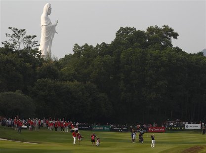 Louis Oosthuizen (R) of South Africa hits on the 18th fairway in front of a Buddhist Guanyin statue during the third day of the WGC-HSBC Cha Louis Oosthuizen (R) of South Africa hits on the 18th fairway in front of a Buddhist Guanyin statue during the third day of the WGC-HSBC Cha