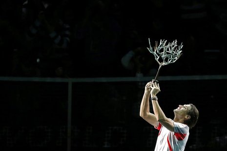 David Ferrer of Spain celebrates with trophy after winning his final men's singles match against Jerzy Janowicz of Poland at the Paris Maste David Ferrer of Spain celebrates with trophy after winning his final men's singles match against Jerzy Janowicz of Poland at the Paris Maste