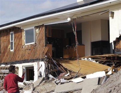 A man photographs a damaged house in the Rockaways neighborhood of the Queens borough of New York November 5, 2012. REUTERS/Brendan McDermid A man photographs a damaged house in the Rockaways neighborhood of the Queens borough of New York November 5, 2012. REUTERS/Brendan McDermid