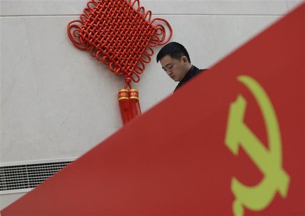 A man walks past a logo of the Communist Party of China (CPC) at a media center for the upcoming18th National Congress of the CPC, which sta A man walks past a logo of the Communist Party of China (CPC) at a media center for the upcoming18th National Congress of the CPC, which sta