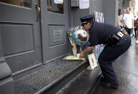 A New York police officer places flowers outside the family home of Etan Patz, who disappeared 33 years ago in New York May 26, 2012. REUTER A New York police officer places flowers outside the family home of Etan Patz, who disappeared 33 years ago in New York May 26, 2012. REUTER