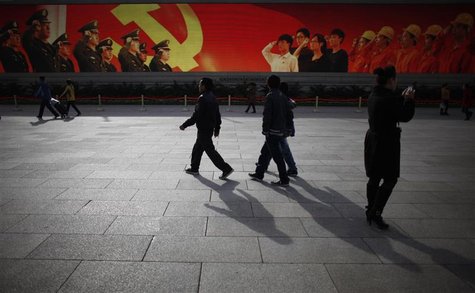 People walk in front of a screen showing propaganda displays near the Great Hall of the People at Beijing's Tiananmen Square, November 7, 20 People walk in front of a screen showing propaganda displays near the Great Hall of the People at Beijing's Tiananmen Square, November 7, 20