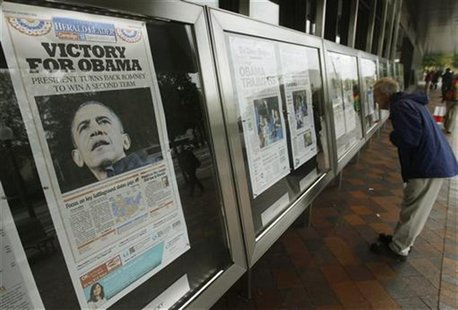 People view various newspaper front pages showing President Barack Obama's victory over Republican presidential candidate Mitt Romney on dis People view various newspaper front pages showing President Barack Obama's victory over Republican presidential candidate Mitt Romney on dis