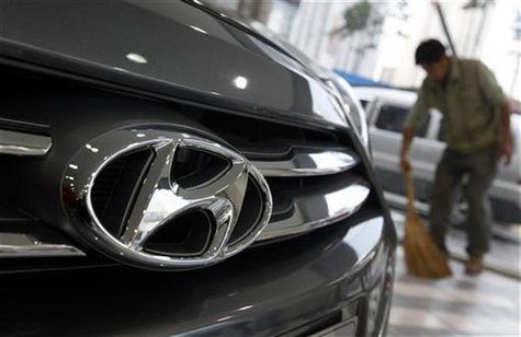 The logo of Hyundai Motor is seen on the on a car as a worker sweeps a floor at a Hyundai dealership in Seoul October 25, 2012. REUTERS/Kim The logo of Hyundai Motor is seen on the on a car as a worker sweeps a floor at a Hyundai dealership in Seoul October 25, 2012. REUTERS/Kim