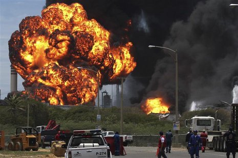 Fuel storage tanks are seen on fire at Amuay oil refinery in Punto Fijo in the Peninsula of Paraguana August 27, 2012. REUTERS/Marife Cuauro Fuel storage tanks are seen on fire at Amuay oil refinery in Punto Fijo in the Peninsula of Paraguana August 27, 2012. REUTERS/Marife Cuauro