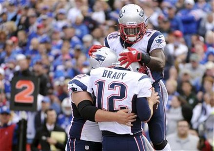 New England Patriots offensive lineman Ryan Wendell (L), quarterback Tom Brady (12) and running back Brandon Bolden (38) celebrate Brady's r New England Patriots offensive lineman Ryan Wendell (L), quarterback Tom Brady (12) and running back Brandon Bolden (38) celebrate Brady's r