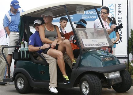 Rory McIlroy of Northern Ireland and girlfriend tennis player Caroline Wozniacki of Denmark ride in a buggy after the rain-delayed second ro Rory McIlroy of Northern Ireland and girlfriend tennis player Caroline Wozniacki of Denmark ride in a buggy after the rain-delayed second ro