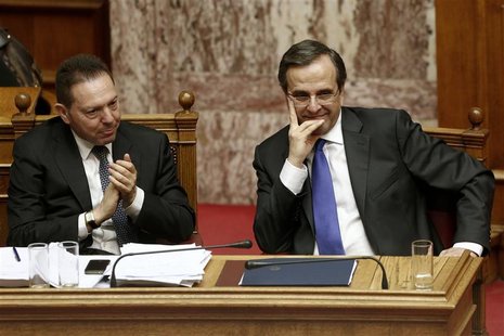 Greece's Finance Minister Yannis Stournaras (L) applauds as Prime Minister Antonis Samaras looks on during a parliament session in Athens No Greece's Finance Minister Yannis Stournaras (L) applauds as Prime Minister Antonis Samaras looks on during a parliament session in Athens No