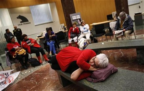 A member of the Mortgage Victims' Platform (PAH) rests as they stage a sit-in protest inside a branch of nationalized lender Bankia in Madri A member of the Mortgage Victims' Platform (PAH) rests as they stage a sit-in protest inside a branch of nationalized lender Bankia in Madri