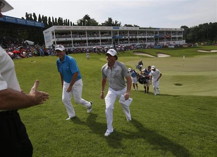 Rory McIlroy of Northern Ireland is congratulated by officials after he finished the final round of the Barclays Singapore Open golf tournam Rory McIlroy of Northern Ireland is congratulated by officials after he finished the final round of the Barclays Singapore Open golf tournam