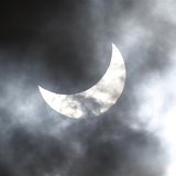 Clouds obscure the moon passing in front of the sun as it approaches a full solar eclipse in the northern Australian city of Cairns November