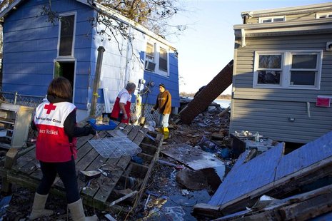 Red Cross volunteers Jessica Elam and Gilbert Abney check on Rob Fragetti, who is attempting to salvage items with his neighbors in their de Red Cross volunteers Jessica Elam and Gilbert Abney check on Rob Fragetti, who is attempting to salvage items with his neighbors in their de