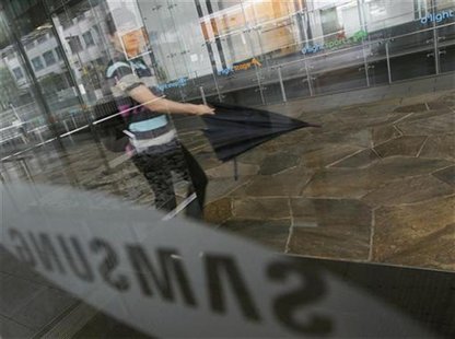 A man walks with an umbrella at the compound of the headquarters of Samsung Electronics in Seoul July 6, 2012. REUTERS/Lee Jae-Won A man walks with an umbrella at the compound of the headquarters of Samsung Electronics in Seoul July 6, 2012. REUTERS/Lee Jae-Won