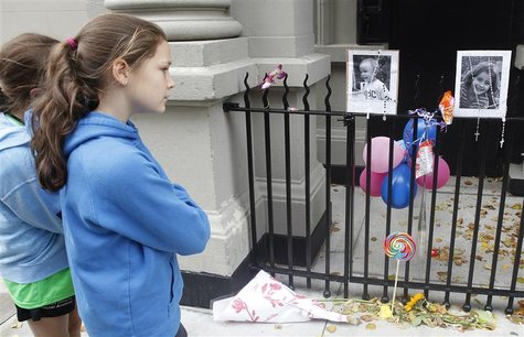 A young girl looks at a makeshift memorial left outside the Krim family apartment in New York, October 28, 2012. REUTERS/Carlo Allegri A young girl looks at a makeshift memorial left outside the Krim family apartment in New York, October 28, 2012. REUTERS/Carlo Allegri