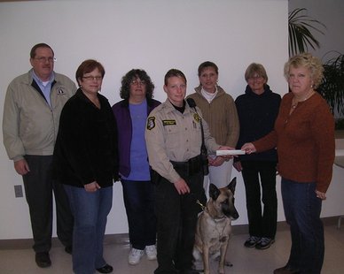Allegan Co. Sheriff's Deputy Kim Thornington, with "Lucky" the dog to her left, receives a $3,000 check from Kim Caines of the Holland Kennel Club in a ceremony at the Howard Miller Center in Zeeland. (photo courtesy Allegan Co. Sheriff's Dept.) Allegan Co. Sheriff's Deputy Kim Thornington, with "Lucky" the dog to her left, receives a $3,000 check from Kim Caines of the Holland Kennel Club in a ceremony at the Howard Miller Center in Zeeland. (photo courtesy Allegan Co. Sheriff's Dept.)