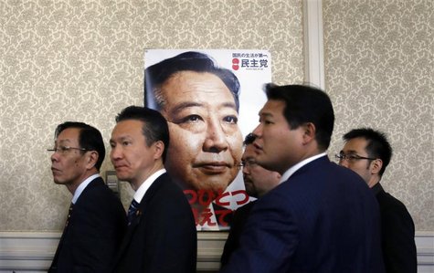 Members of the ruling Democratic Party of Japan stand next to a poster of Japanese Prime Minister Yoshihiko Noda after a meeting at the parl Members of the ruling Democratic Party of Japan stand next to a poster of Japanese Prime Minister Yoshihiko Noda after a meeting at the parl
