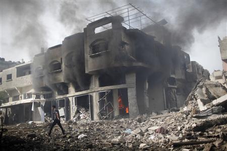 A Palestinian walks past a burning house after an Israeli air strike in Gaza City November 18, 2012. REUTERS/Ahmed Jadallah A Palestinian walks past a burning house after an Israeli air strike in Gaza City November 18, 2012. REUTERS/Ahmed Jadallah