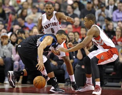Minnesota Timberwolves guard Brandon Roy (L) grabs a loose ball in front of Toronto Raptors defenders Alan Anderson and DeMar DeRozan (R) du Minnesota Timberwolves guard Brandon Roy (L) grabs a loose ball in front of Toronto Raptors defenders Alan Anderson and DeMar DeRozan (R) du