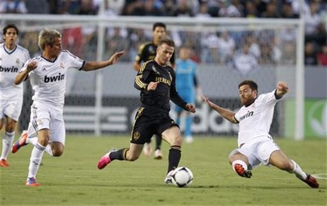 Los Angeles Galaxy's David Beckham (C) chases the ball between Real Madrid's Fabio Coentrao (L) and Xabi Alonso (R) during the first half of Los Angeles Galaxy's David Beckham (C) chases the ball between Real Madrid's Fabio Coentrao (L) and Xabi Alonso (R) during the first half of