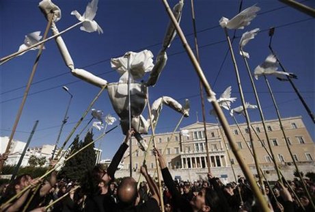 Protesters use a life-size puppet made of paper symbolizing a Greek during an anti-austerity rally in front of the parliament building in ce Protesters use a life-size puppet made of paper symbolizing a Greek during an anti-austerity rally in front of the parliament building in ce