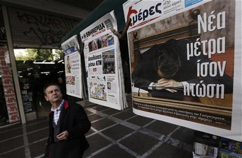 A man walks past a newspaper featuring Greek Prime Minister Antonis Samaras in central Athens November 15, 2012. REUTERS/John Kolesidis A man walks past a newspaper featuring Greek Prime Minister Antonis Samaras in central Athens November 15, 2012. REUTERS/John Kolesidis