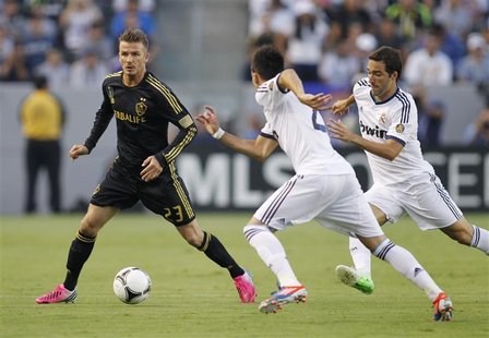Los Angeles Galaxy's David Beckham (L) controls the ball as Real Madrid's Jose Maria Callejon (C) and Gonzalo Higuain (R) defend during the Los Angeles Galaxy's David Beckham (L) controls the ball as Real Madrid's Jose Maria Callejon (C) and Gonzalo Higuain (R) defend during the