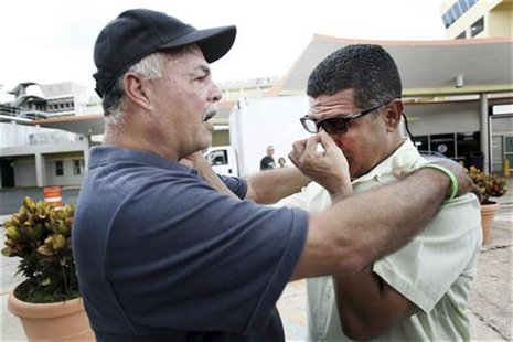 Former boxer Lovi Callejas (R) and friend Ruben Borrali console each other as they await news on the condition of former Puerto Rican welter Former boxer Lovi Callejas (R) and friend Ruben Borrali console each other as they await news on the condition of former Puerto Rican welter