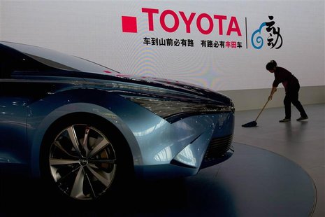 A worker cleans next to a Toyota NS4 plug-in hybrid concept car during the media preview of the 10th China International Automobile Exhibiti A worker cleans next to a Toyota NS4 plug-in hybrid concept car during the media preview of the 10th China International Automobile Exhibiti
