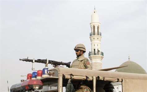 A soldier from Pakistan's paramilitary Rangers forces patrols on a road ahead of the Ashura ceremony to mark the death of Hussein, the grand A soldier from Pakistan's paramilitary Rangers forces patrols on a road ahead of the Ashura ceremony to mark the death of Hussein, the grand
