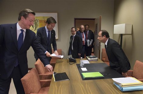French President Francois Hollande (R) takes his seat before a meeting with British Prime Minister David Cameron (L) and Dutch Prime Ministe French President Francois Hollande (R) takes his seat before a meeting with British Prime Minister David Cameron (L) and Dutch Prime Ministe