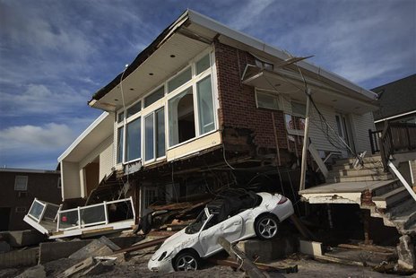 An automobile sits under a home damaged by superstorm Sandy in the Belle Harbor section of the Queens borough of New York November 14, 2012. An automobile sits under a home damaged by superstorm Sandy in the Belle Harbor section of the Queens borough of New York November 14, 2012.