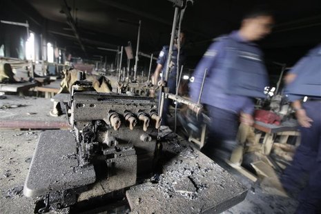 Members of the police inspect the burnt interior of a garment factory after a fire in Savar November 25, 2012. REUTERS/Andrew Biraj Members of the police inspect the burnt interior of a garment factory after a fire in Savar November 25, 2012. REUTERS/Andrew Biraj