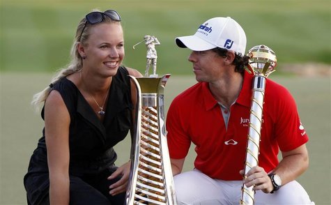 Rory McIlroy of Northern Ireland smiles at his girlfriend tennis player Caroline Wozniacki of Denmark as he poses with his trophy after the Rory McIlroy of Northern Ireland smiles at his girlfriend tennis player Caroline Wozniacki of Denmark as he poses with his trophy after the