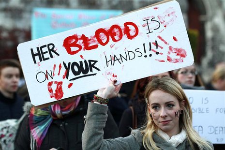 A woman holds a poster during a vigil in Dublin November 17, 2012, in memory of Savita Halappanavar and in support of changes to abortion la A woman holds a poster during a vigil in Dublin November 17, 2012, in memory of Savita Halappanavar and in support of changes to abortion la