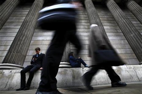 A man and woman use their mobile phones as commuters walk past the columns of the Bank of England in the City of London, July 3, 2012. REUTE A man and woman use their mobile phones as commuters walk past the columns of the Bank of England in the City of London, July 3, 2012. REUTE