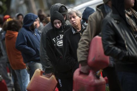 Residents try to keep warm as they line up for gasoline at a temporary fueling station at the National Guard armory in the Staten Island Bor Residents try to keep warm as they line up for gasoline at a temporary fueling station at the National Guard armory in the Staten Island Bor