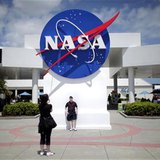 Tourists take pictures of a NASA sign at the Kennedy Space Center visitors complex in Cape Canaveral, Florida April 14, 2010. REUTERS/Carlos