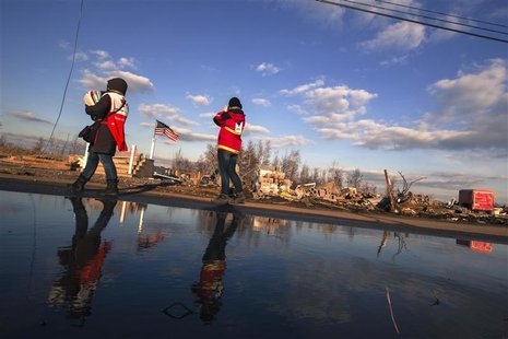 Red Cross volunteers walk past the remaining foundations of homes destroyed by the storm surge of superstorm Sandy in the Staten Island boro Red Cross volunteers walk past the remaining foundations of homes destroyed by the storm surge of superstorm Sandy in the Staten Island boro
