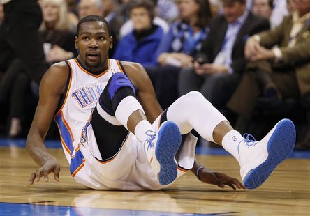 Oklahoma City Thunder forward Kevin Durant slides to the floor on a play against the Houston Rockets in the second half of NBA basketball ga Oklahoma City Thunder forward Kevin Durant slides to the floor on a play against the Houston Rockets in the second half of NBA basketball ga