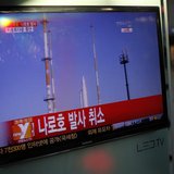 A passenger walks past a TV screen broadcasting the news that the launch of Korea Space Launch Vehicle-1 (KSLV-1), or Naro, was cancelled du A passenger walks past a TV screen broadcasting the news that the launch of Korea Space Launch Vehicle-1 (KSLV-1), or Naro, was cancelled du