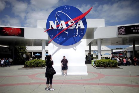 Tourists take pictures of a NASA sign at the Kennedy Space Center visitors complex in Cape Canaveral, Florida April 14, 2010. REUTERS/Carlos Tourists take pictures of a NASA sign at the Kennedy Space Center visitors complex in Cape Canaveral, Florida April 14, 2010. REUTERS/Carlos