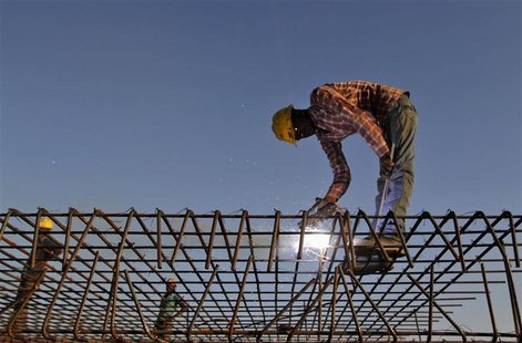 A worker welds iron rods at the construction site of a commercial complex in the western Indian city of Ahmedabad November 29, 2012. India's A worker welds iron rods at the construction site of a commercial complex in the western Indian city of Ahmedabad November 29, 2012. India's
