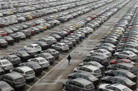 An employee walks past new cars at the parking lot of Changan Ford Mazda Automobile Co. Ltd, Ford Motor's joint venture in China, in Chongqi An employee walks past new cars at the parking lot of Changan Ford Mazda Automobile Co. Ltd, Ford Motor's joint venture in China, in Chongqi