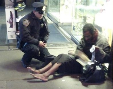 New York police officer Larry DePrimo gives a homeless man a pair of boots and socks in Times Square in this November 14, 2012 handout photo New York police officer Larry DePrimo gives a homeless man a pair of boots and socks in Times Square in this November 14, 2012 handout photo
