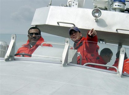 U.S. Coast Guard Coxswain Petty Officer 2nd Class Terrell Horne (R) points the way as Lt. Colonel. Rasheed Mansoor R. M. Al-Borashid, of Qat U.S. Coast Guard Coxswain Petty Officer 2nd Class Terrell Horne (R) points the way as Lt. Colonel. Rasheed Mansoor R. M. Al-Borashid, of Qat