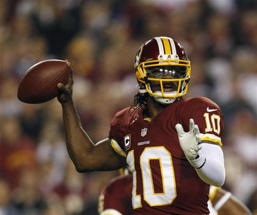 Washington Redskins quarterback Robert Griffin III throws against the New York Giants defense during the first half of their NFL football ga Washington Redskins quarterback Robert Griffin III throws against the New York Giants defense during the first half of their NFL football ga