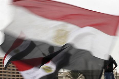 Anti-Mursi protesters, seen through Egyptian flags, chant anti-Mursi slogans in Tahrir square in Cairo December 4, 2012. REUTERS/Asmaa Wagui Anti-Mursi protesters, seen through Egyptian flags, chant anti-Mursi slogans in Tahrir square in Cairo December 4, 2012. REUTERS/Asmaa Wagui