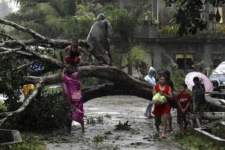 Residents saw an uprooted tree to clear the road after Typhoon Bopha hit Tagum City, southern Philippines December 4, 2012. Typhoon Bopha ma Residents saw an uprooted tree to clear the road after Typhoon Bopha hit Tagum City, southern Philippines December 4, 2012. Typhoon Bopha ma