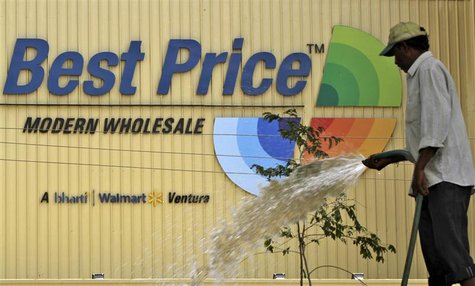 A municipal worker pours water on saplings near to a newly opened Bharti Wal-Mart Best Price Modern wholesale store in the southern Indian c A municipal worker pours water on saplings near to a newly opened Bharti Wal-Mart Best Price Modern wholesale store in the southern Indian c